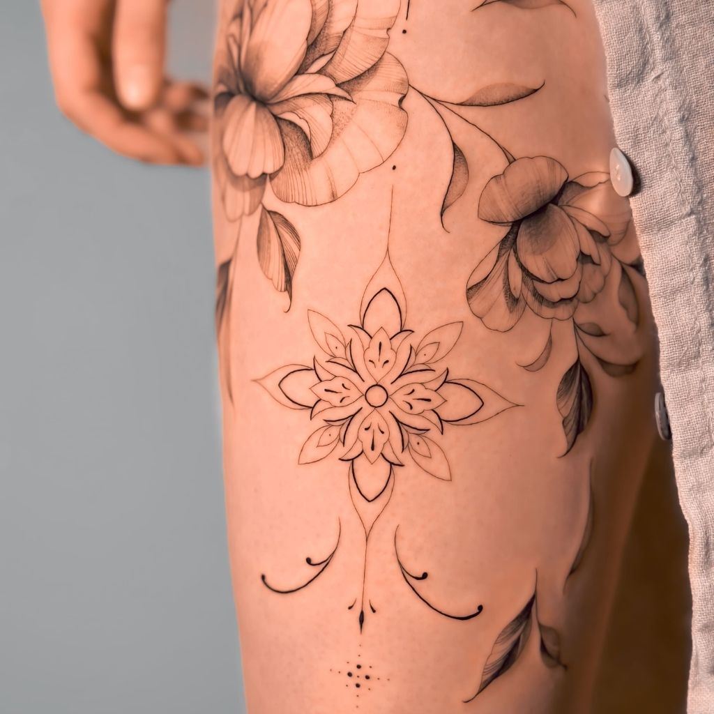 Tatouage pivoine et ornement mandala fine line sur la cuisse réalisé au salon Encorps Studio à Nîmes | Garons